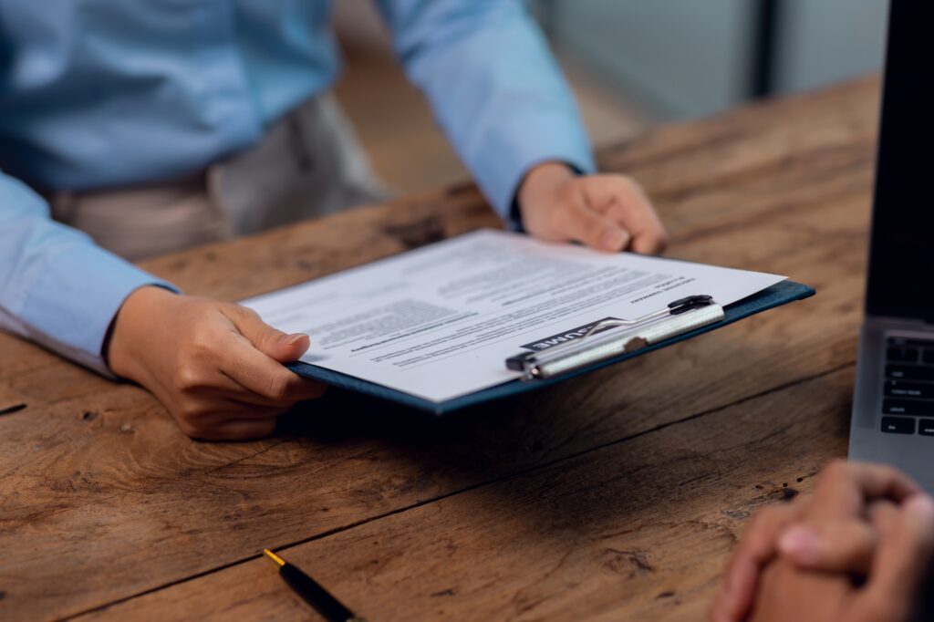 HR Consultant reading an hr policy document in preparation for a HR audit with a business owner in Sussex, Surrey and London to ensure legal compliance