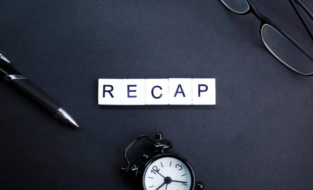 glasses, pen and bell clock with letters of the alphabet or the word recap