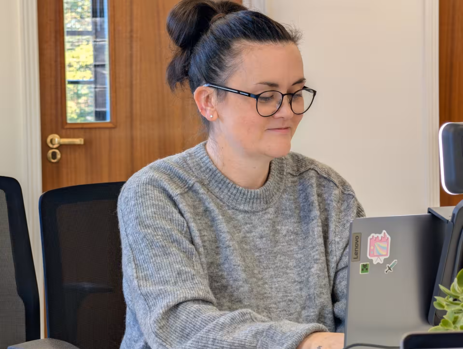 A close up of Claire Cross working on her laptop.